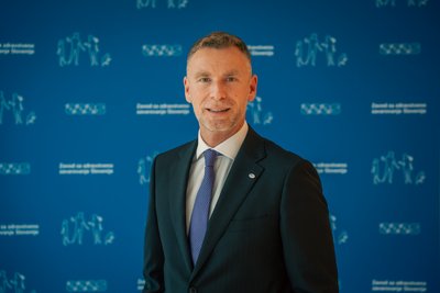 Yannis Natsis, direktor Evropskega združenja nosilcev obveznih socialnih zavarovanj (ESIP)2, zadaj modra stena z logotipi ZZZS.