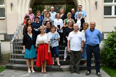 Skupinska fotografija 22 ljudi zunaj na stopnicah, v ospredju doc. dr. Tatjana Mlakar, generalna direktorica ZZZS